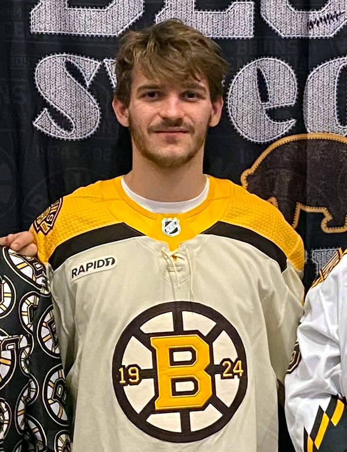 Jakub Lauko in Boston Bruins uniform skating with the puck